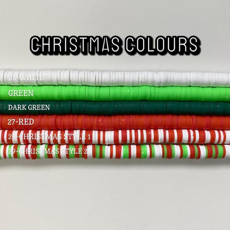 May include: A close-up of a variety of colorful beads, including white, green, dark green, red, and red and white striped beads. The beads are arranged in rows, with the text "CHRISTMAS COLOURS" at the top. The beads are labeled with numbers and descriptions, such as "26-WHITE", "GREEN", "DARK GREEN", "27-RED", "28-CHRISTMAS STYLE 1", and "29-CHRISTMAS STYLE 2".