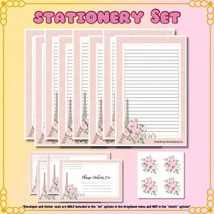 May include: A stationery set featuring pink paper with the Eiffel Tower and floral designs. The set includes lined paper, notecards, and stickers. The text "STATIONERY SET" is at the top. The notecards read "Please Deliver To: Paris".