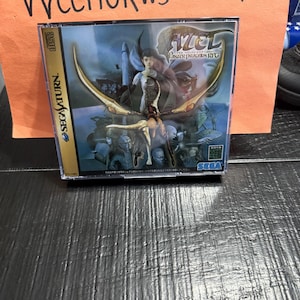 May include: A SEGA Saturn game case for the game titled "AZEL Panzer Dragoon RPG". The case features a fantasy illustration with a woman and dragon-like creatures. The case is in a plastic jewel case.