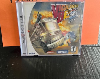 May include: A Sega Dreamcast game case for Vigilante 8: 2nd Offense. The case is silver with a black and red design. The game features a large bus with a gun on top. The game is rated T for Teen by the ESRB.