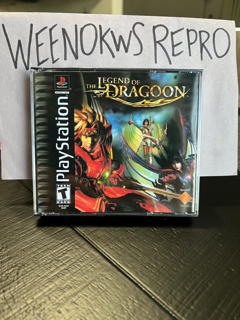 K&ouml;nnte beinhalten: Ein PlayStation-Spielecase f&uuml;r The Legend of Dragoon. Das Case ist schwarz mit einem roten, gr&uuml;nen und goldenen Design. Das Spiel ist von der ESRB mit T f&uuml;r Teenager bewertet.