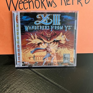 May include: A CD case for the video game Ys III: Wanderers From Ys for the TurboGrafx-16. The case features a red and black image of a demon with a sword-wielding warrior in the foreground. The text "Ys III" and "Wanderers From Ys" is printed in white on a black background.