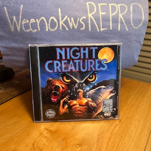 Op de afbeelding: Een CD-hoes voor het TurboGrafx-16-videospel Night Creatures. De hoes toont een gespierde man die vecht tegen een beer, wolf en uil tegen een sterrenhemel met volle maan.