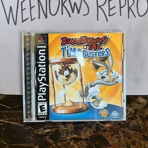 Könnte beinhalten: Ein PlayStation-Videospiel-Etui für Bugs Bunny & Taz: Time Busters. Das Etui ist blau und zeigt ein Bild von Bugs Bunny und Taz, die vor einer Sanduhr stehen. Das Spiel ist von der ESRB mit "E" für Everyone bewertet.