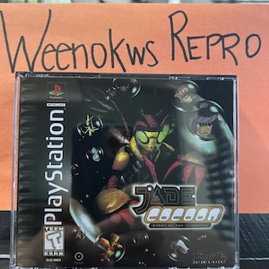 May include: A PlayStation video game case with a black background and a colorful image of a character in a red and black suit. The game title is "Jade Cocoon: Story of the Tamamayu".