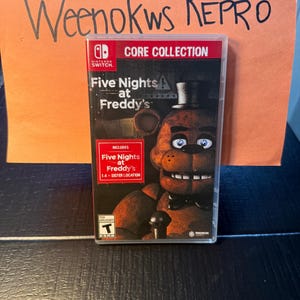 Peut inclure: Boîtier de jeu Nintendo Switch pour "Five Nights at Freddy's: Core Collection". La couverture présente un personnage d'ours brun avec un chapeau haut de forme et un nœud papillon. Le jeu comprend "Five Nights at Freddy's 1-4 + Sister Location."