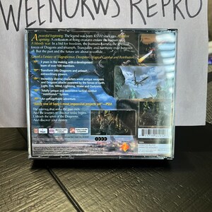 K&ouml;nnte beinhalten: Ein PlayStation 2-Spielecase f&uuml;r das Spiel "Dragoons" mit blauem und gr&uuml;nem Hintergrund. Das Case zeigt einen Drachen, der &uuml;ber einen Wald fliegt. Der Text auf dem Case lautet "Unveil a Fantasy of Magnificence, Deception, Magical Combat and Retribution."