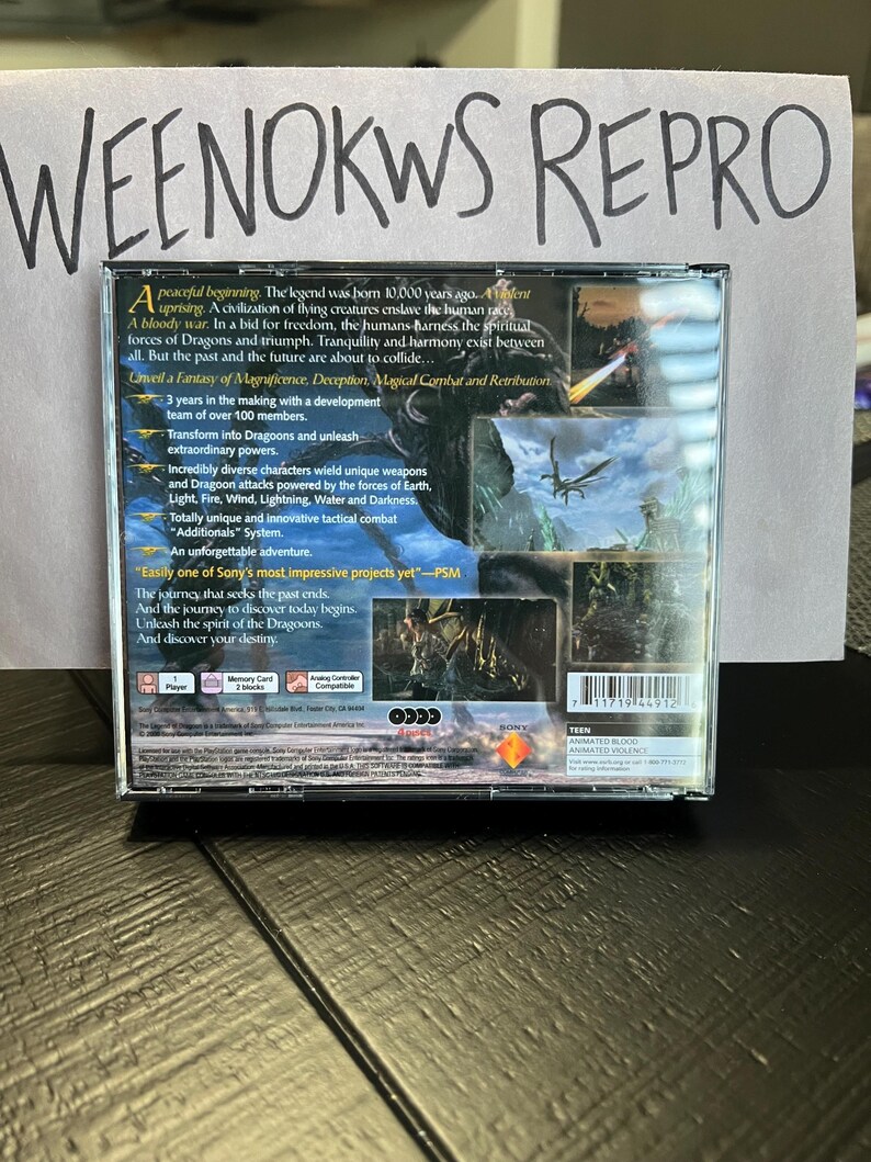 K&ouml;nnte beinhalten: Ein PlayStation 2-Spielecase f&uuml;r das Spiel "Dragoons" mit blauem und gr&uuml;nem Hintergrund. Das Case zeigt einen Drachen, der &uuml;ber einen Wald fliegt. Der Text auf dem Case lautet "Unveil a Fantasy of Magnificence, Deception, Magical Combat and Retribution."