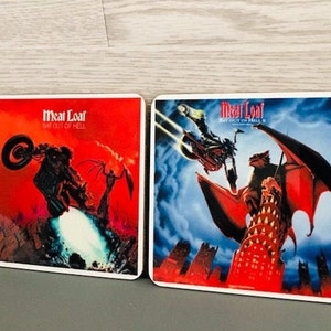 Op de afbeelding: Twee vierkante onderzetters met albumkunst van Meat Loafs "Bat Out of Hell" albums. De linker onderzetter heeft een rode achtergrond met een motorfiets en een figuur met vleugels. De rechter onderzetter heeft een blauwe achtergrond met een gevleugelde demon en een figuur op een motorfiets.