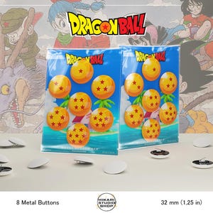 Peut inclure: Ensemble de huit boutons métalliques avec un design Dragon Ball, chacun avec une sphère orange et des étoiles rouges. Les boutons mesurent 3,2 cm de diamètre. L'emballage présente des personnages et le logo Dragon Ball.