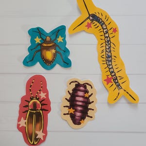 May include: Four colourful insect illustrations on a white background. The insects include a beetle with a teal body, a centipede-like creature, and two other beetle-like insects. Each insect has star accents.