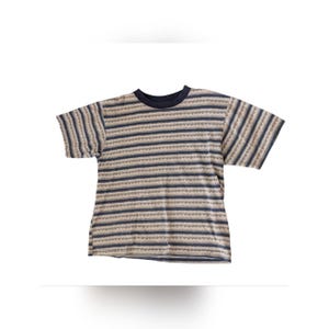 May include: A short-sleeved t-shirt with horizontal stripes in shades of blue, tan, and brown. The shirt has a navy blue crew neck and a relaxed fit. The fabric appears to be a soft knit.