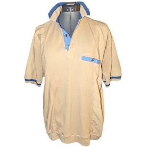 May include: Tan short-sleeved shirt with blue accents. The shirt features a blue collar, a blue pocket, and blue trim on the sleeves. The shirt has a vertical striped pattern and a button-down neckline.