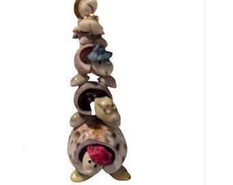 Arte vintage con conchas marinas: 5 tortugas apiladas con cabezas oscilantes, sombreros de paja y gafas.