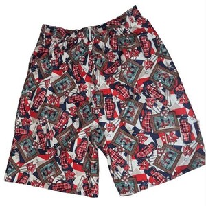 May include: A pair of patterned shorts with an elastic waistband. The shorts feature a repeating pattern of framed images, golf bags, and geometric shapes in red, white, and navy blue. The shorts are made of a lightweight fabric.