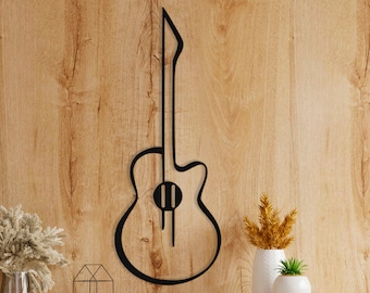 Op de afbeelding: Zwarte metalen gitaar silhouet wanddecoratie op een houten lambrisering muur boven een houten kast met lades.