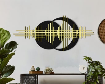 May include: Black and gold geometric wall art with intersecting lines and circles. The art is mounted on a white wall above a black metal shelf with a woven basket and books.