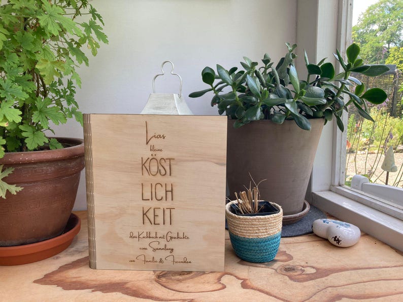 May include: A wooden sign with the text "Lieb  blume  kostlich  keit  der  Kallbach  at  Gedichte  eine  Sammlung  -  Familie  &  Freunde" engraved on it.