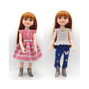 May include: Two dolls with red hair and fair skin. One doll wears a pink and gray crochet dress with a silver belt and glitter boots. The other doll wears a gray crochet top, blue jeans with floral and butterfly appliques, and glitter boots.