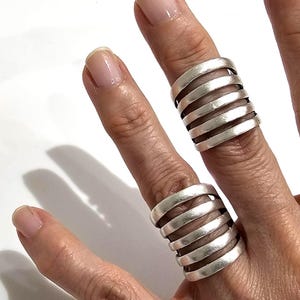 Anello massiccio in argento, con fascia larga, regolabile, dal design minimalista e brutalista, un vero gioiello scultoreo.