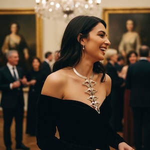 Anatomical silver statement necklace worn at elegant gala evening, beautiful woman off shoulder black dress laughing, handmade sculptural silver plated geometric necklace wearable art