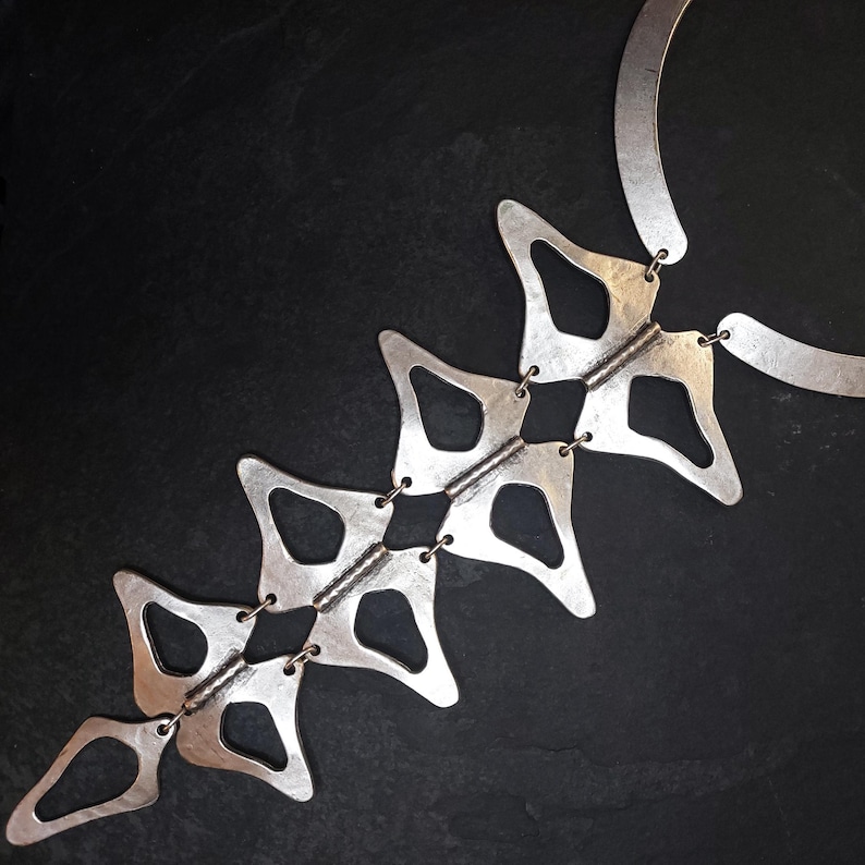 Anatomical silver statement necklace black marble flatlay, handmade sculptural silver plated geometric necklace luxury product photography, wearable art jewelry Gozemre Atelier
