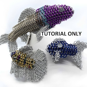 Könnte beinhalten: Drei silberne, blaue und violette Kettenhemd-Fischskulpturen. Die Fische bestehen aus kleinen, miteinander verflochtenen Metallringen. Die Fische befinden sich auf einer weißen Oberfläche. "Nur Tutorial" steht in schwarzer Schrift auf der Oberfläche.