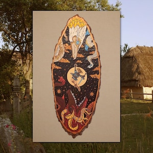 May include: An oval-shaped wooden plaque featuring a detailed illustration of a character reaching toward a bright moon. The artwork includes a large bird head at the top, a dark starry sky, and a red, tentacled creature at the bottom.