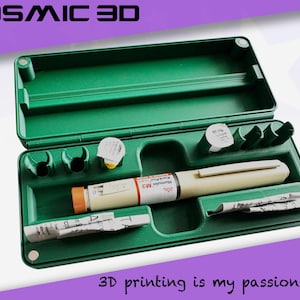 May include: A green plastic case with an open lid, containing medical supplies. Inside are an insulin pen, needles, and other items. The text "COSMIC 3D" is at the top, and "3D printing is my passion" is at the bottom.