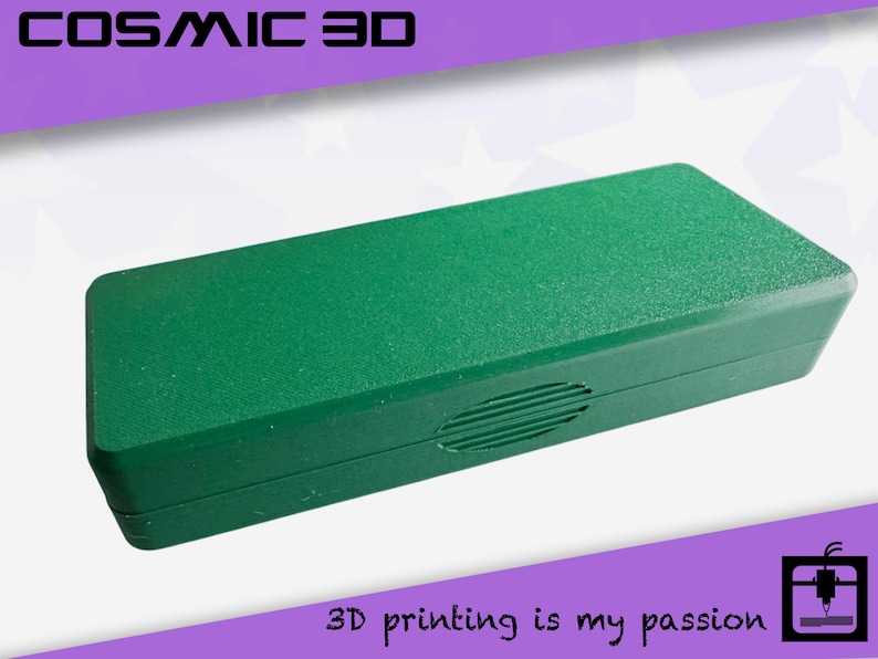 May include: A rectangular, textured, green box with rounded edges. The box has a small, oval-shaped vent on the side. The text "COSMIC 3D" is at the top, and "3D printing is my passion" is at the bottom.