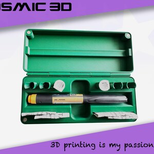 May include: Open green case containing medical supplies, including a pen-like device with yellow and black accents, and small white containers. The text "COSMIC 3D" is at the top, and "3D printing is my passion" is at the bottom.