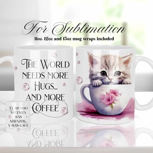 May include: White ceramic mug with a cute kitten peeking out of a teacup. The mug has the text "The world needs more hugs... and more coffee" printed on it. The text "El mundo necesita mas abrazos... y mas cafe" is also printed on the mug.