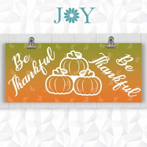 May include: A banner with an orange and green gradient background. The banner has the text "Be Thankful" on each side and a white silhouette of three pumpkins in the center.