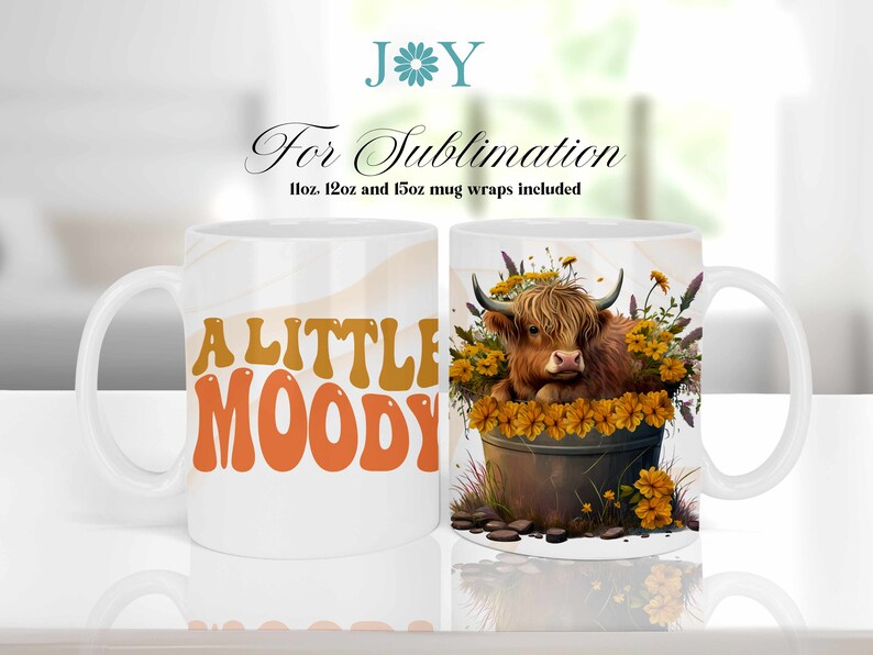May include: White ceramic mug with a design of a Highland cow in a pot of yellow flowers. The text "A LITTLE MOODY" is on the other side of the mug.