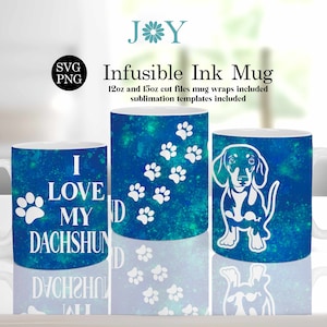 Puede incluir: Tres tazas de cerámica blanca con un diseño de galaxia azul y verde. Una taza dice "Amo a mi Dachshund" con huellas de patas. Otra taza tiene huellas de patas. La tercera taza tiene una silueta blanca de un dachshund.