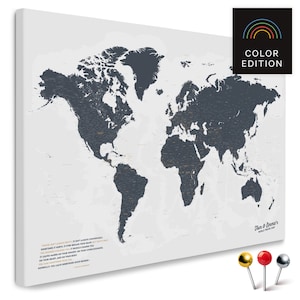 Peut inclure: Une carte du monde grise sur fond blanc. La carte est imprimée sur toile et a un aspect vieilli. La carte est entourée d'une bordure blanche. Le texte "Color Edition" est imprimé en arc-en-ciel au-dessus de la carte. Le texte "Don & Emma's World Travel Map" est imprimé dans le coin inférieur droit de la carte. Trois punaises sont représentées sous la carte : une rouge, une dorée et une argentée.