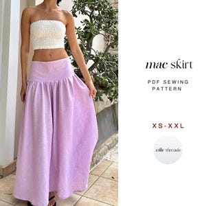 May include: A person wearing a white bandeau top and a long, lilac skirt. The skirt is gathered at the waist and falls to the floor. Text on the right says "mae skirt" and "PDF Sewing Pattern" with size range "XS-XXL".