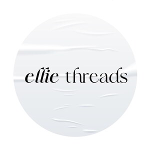 May include: White circle sticker with a wrinkled texture and the text "ellie threads" in black.