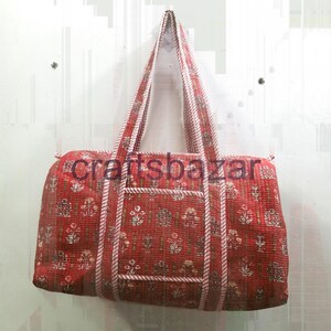 Könnte beinhalten: Rote und braune Tragetasche mit floralem Muster, passenden Griffen und einer Vordertasche. Die Tasche hat ein gestepptes Design und der Text "craftsbazar" ist auf der Vorderseite zu sehen. Die Tasche hängt vor einem weißen Hintergrund.