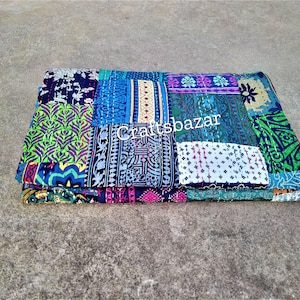 Könnte beinhalten: Gefaltete Patchwork-Quilt mit einer Vielzahl von gemusterten Stoffquadraten in Blau-, Grün-, Lila- und Weißtönen. Der Quilt hat sichtbare Nähte und der Text "craftsbazar" ist sichtbar.