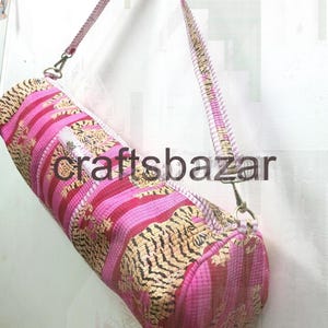 May include: A cylindrical yoga mat bag with a pink and gold tiger stripe pattern. The bag has a matching strap and the text "craftsbazar" is visible on the side.
