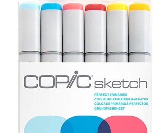 May include: A set of six Copic Sketch markers in a white package. The markers have gray barrels and colored caps in blue, pink, red, and yellow. The package includes the text "COP/C sketch" and "PERFECT PRIMARIES".