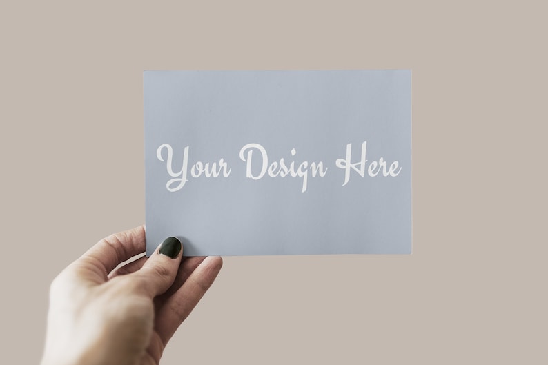 以下が含まれることがあります： 白い文字で「Your Design Here」と書かれた薄い青色のカードを手に持っている