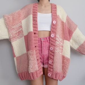 Può includere: Un cardigan a quadri rosa e bianco con bordi pelosi e bottoni.