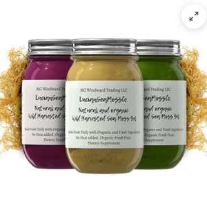 Op de afbeelding: Drie glazen potten met etiketten met de tekst "Lucinnsen Mosslo. Natuurlijk en biologisch wild geoogst zeewiergel." De potten zijn gevuld met een paarse, gele en groene gel. De potten staan op een bed van gedroogd zeewier.