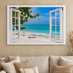 May include: A rectangular wall art print featuring a white window frame with open shutters looking out onto a tropical beach scene with turquoise ocean water, white sand, and green tree branches under a bright blue sky with white clouds.
