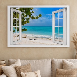 May include: A rectangular wall art print featuring an open white window frame looking out onto a tropical beach scene with turquoise ocean water, white sand, and green tree branches under a bright blue sky with scattered white clouds.