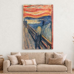 a large painting of Edvard Munch's iconic work "The Scream" hanging on a wall above a beige sofa with decorative pillows.