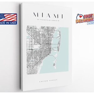 May include: A white canvas print featuring a detailed map of Miami, Florida, with the city's name at the top. The map is in black and white, with a light blue section representing the ocean. The text "UNITED STATES" is at the bottom.