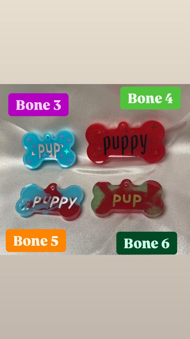 May include: Four dog bone-shaped pet tags in various colors. The tags are labeled "Pup" and "Puppy" in different fonts. The tags are blue, red, and green with glitter accents. The tags are labeled "Bone 3", "Bone 4", "Bone 5", and "Bone 6".